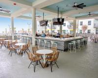 ein Restaurant mit Tischen und Stühlen und einer Bar in der Unterkunft Holiday Inn Club Vacations Myrtle Beach Oceanfront in Myrtle Beach