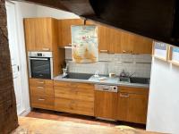 a kitchen with wooden cabinets and a sink at Villa Roc Vaudieu - Charmante maison de pêcheurs in Étretat
