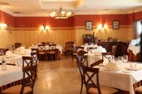 een eetkamer met witte tafels en stoelen bij Hotel Villa De Ferias in Medina del Campo