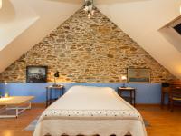 a bed in a room with a stone wall at Holiday Home Ville Guerin by Interhome in Saint-Coulomb