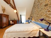 a bedroom with a bed and a stone wall at Holiday Home Ville Guerin by Interhome in Saint-Coulomb