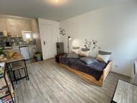 a bedroom with a bed and a kitchen at Studio centre village Soligny la Trappe proche Mortagne au perche in Soligny-la-Trappe