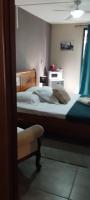 a bedroom with two beds and a chair and a window at Bois de Santal Chambre d&#39;hôtes in Saint-Pierre