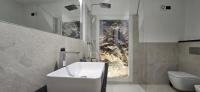 a bathroom with a sink and a toilet and a window at The white cave- Bluchalet in Riomaggiore