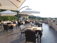 Un restaurante con mesas, sillas y sombrillas. en UNICO Cannamele Escape Tropea by Life Resorts, en Parghelia