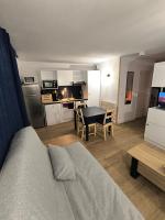 a room with a bed and a kitchen with a table at studio tout équipé in Jausiers