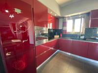 a red kitchen with red cabinets and a window at Luxury view apartment 10min from Athens airport in Koropi