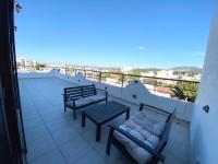 two benches and a table on a balcony with a view at Luxury view apartment 10min from Athens airport in Koropi