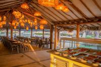 a restaurant with tables and chairs and lights at Sunsol Isla Caribe in Puerto Fermín