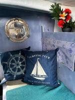 a pillow with a sailboat on it next to a clock at Séjour sur voilier in Antibes