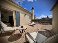 a patio with chairs and a table and a table and chairs at Les 5 Arches in Sisco