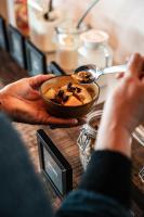 a person holding a bowl of food on a table at Brouwersdam Stay in Ouddorp