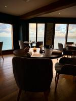 a dining room with a table and chairs and the ocean at Kittiwake Cottage - Charming harbour-side cottage, luxury interiors in Port Isaac