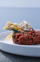 un plato de comida con carne y patatas fritas. en Hotel Plein Large, en Bandol