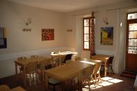 Un comedor con mesas y sillas de madera. en Le Dauphiné, en Châtillon-en-Diois