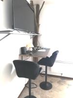 a room with a desk with two chairs and a television at L&#39;éveil in Vittefleur