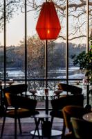 ケルヴィニャックにあるDomaine de Locguénolé & Spa - Relais & Chateauxのテーブルと椅子、赤ランプのあるレストラン