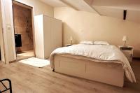 Un dormitorio blanco con una cama y un baño. en Appartement entier full équipé, en Charleroi