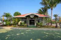 a building with a red roof and palm trees at E&G Green Courts Resort at Koroli Hill Station in Nashik