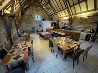 EspagnacにあるDomaine des Etangs de Taysseの木製のテーブルと椅子、キッチンを備えたレストラン