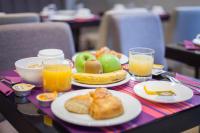 a table with plates of food and glasses of orange juice at Hotel Jenner in Paris