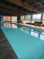 a swimming pool with blue water in a building at studio tout équipé in Jausiers