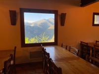 Cette chambre dispose d'une grande fenêtre avec une table et des chaises. dans l'établissement Auberge de Thiéry, à Thiéry