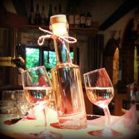 une bouteille de vin et deux verres sur une table dans l'établissement Antjes kleines Nest, à Tröstau