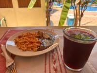 Un plato de comida junto a una bebida en una mesa. en Hotel Bungalows Acuario, en Puerto Escondido