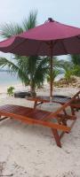 a picnic table and an umbrella on the beach at Jelita Beach Mentawai in Tuapejat