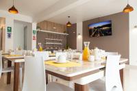 a dining room with a table and white chairs at Las Torres Hotel Boutique in Moquegua