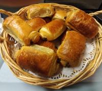 una cesta con cruasanes en una mesa en B&B HOME Caen Centre Gare, en Caen