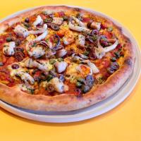 a pizza on a plate on a yellow table at Eastin Grand Hotel Sathorn in Bangkok