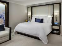 a bedroom with a large white bed and a chair at The Peninsula Chicago in Chicago