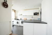 eine weiße Küche mit einer Spüle und einem Geschirrspüler in der Unterkunft Spacieux appartement - Stade de France in Saint-Denis