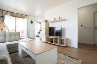 ein Wohnzimmer mit einem Sofa und einem TV in der Unterkunft Spacieux appartement - Stade de France in Saint-Denis