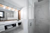 a white bathroom with a shower and a sink at Hotel La Pau in Barcelona