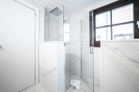 a white bathroom with a shower and a glass door at Hotel La Pau in Barcelona