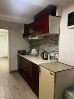 a kitchen with brown cabinets and a counter top at Hostel Tuzla in Tuzla
