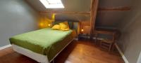 a bedroom with a green bed in a attic at B&amp;B Bon Vivant in Brinay