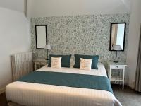 a bedroom with a bed with two tables and two mirrors at Hotel Ty Gwenn La Baule in La Baule