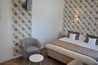 a small bedroom with a bed and a chair at Hotel Ty Gwenn La Baule in La Baule