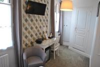 a room with a desk and a tv on a wall at Hotel Ty Gwenn La Baule in La Baule