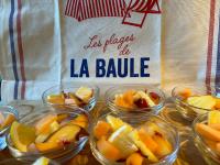 a table topped with bowls of fruit with a sign at Hotel Ty Gwenn La Baule in La Baule