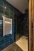 a bathroom with a shower with blue tiled walls at Appartement neuf avec une grande terrasse au cœur du village - 6 personnes in Saint-Sorlin-dʼArves