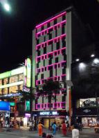 a tall building with pink lights on it at night at Beauty Hotels Taipei - Hotel B6 in Taipei