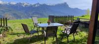 a table and chairs with a view of mountains at Rez de jardin, vue panoramique, plein Sud in Puy-Sanières