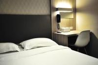 a bedroom with a bed and a desk with a phone at The Riverside Hotel International in Kaohsiung