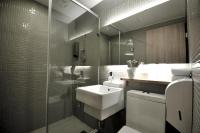 a bathroom with a sink and a glass shower at The Riverside Hotel International in Kaohsiung