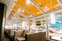 Un comedor con sillas y mesas y techos amarillos. en Superior Inn Hotel and Conference Centre Thunder Bay, en Thunder Bay